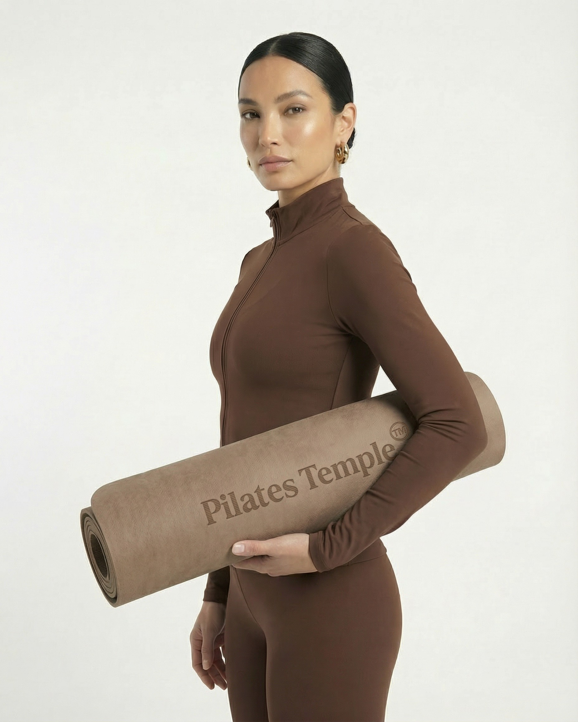 #color-Brun Modèle portant le tapis de Pilates enroulé.