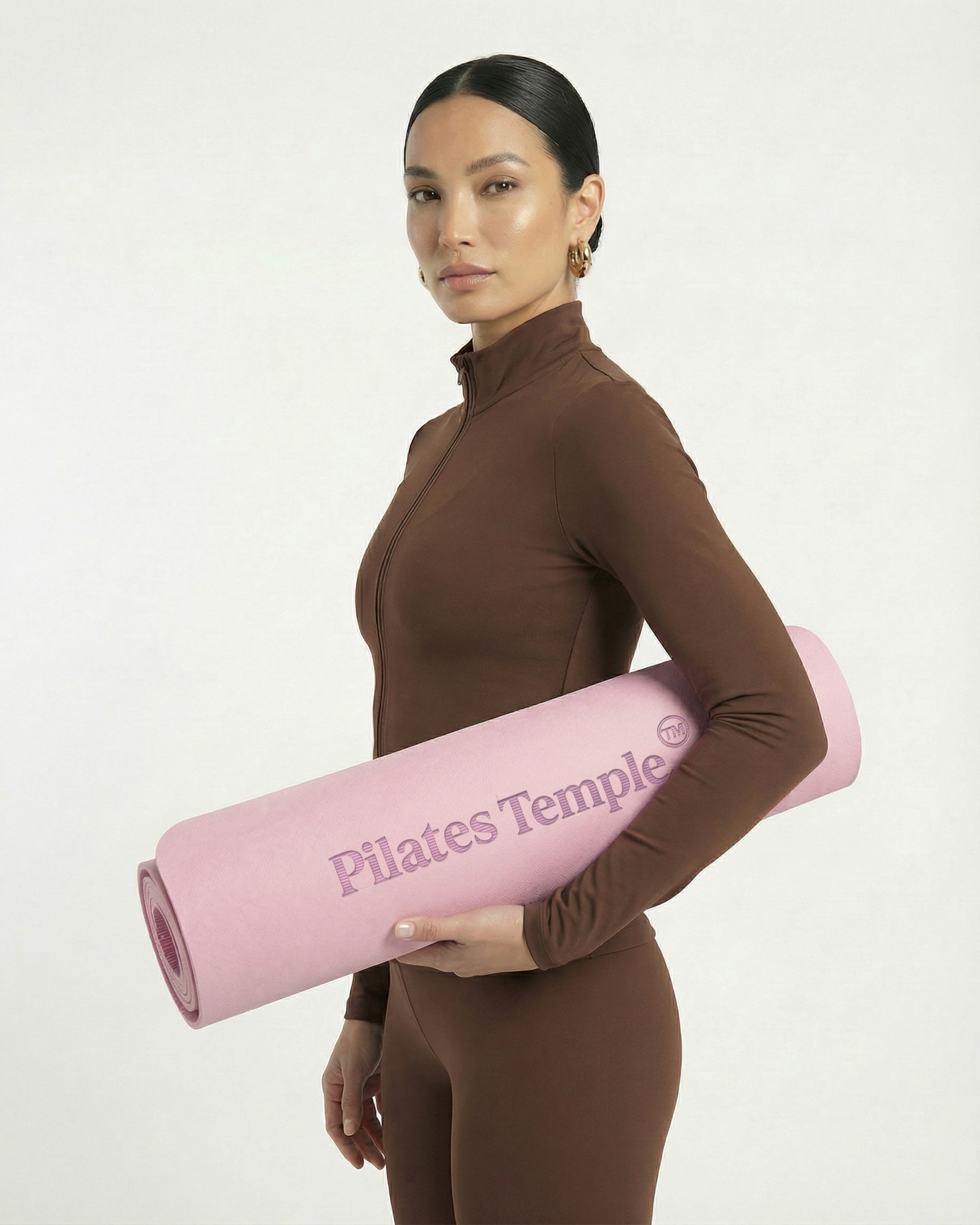 #color-Rose Modèle portant le tapis de Pilates enroulé.